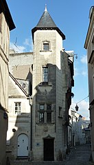 Photographie d'une tour d'escalier à l'angle d'une maison, dans une ruelle.