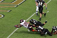 Mike Imod of the Deacons dives for a touchdown as he is tackled by two opponent players