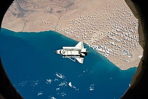 صُورة لِمكُّوُك الفضاء ديسكڤري مُلتقطة من محطَّة الفضاء الدُوليَّة. المنطقة أدنى المكُّوك هي مدينة طرفاية المغربيَّة