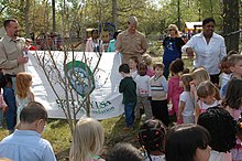 US Navy 060419-N-6700F-173 Naval Amphibious Base Little Creek, Va.'s Child Development Center (CDC) children help Cmdr. Billy Fenton, the base's executive officer, and Jack Kauffman, a forest ranger with Virginia's Dept. of For.jpg