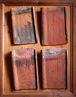 Quatre tuiles anciennes marquées sur le pureau de dates, de texte et de motifs ornementaux