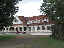 Exterior of a long, white colonial-style building