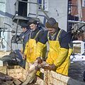 Fiskeriarbeidere i oljehyre og losluer sløyer torsk, trolig i Lofoten på 1970-tallet. Foto: Nordlandsmuseet (Kanstadsamlinga)