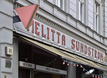 Café Melitta Sundström, Mehringdamm 61, Berlin-Kreuzberg, boasting the „Pink Triangle“ and the historic sign of the (Prinz) Eisenherz book store.