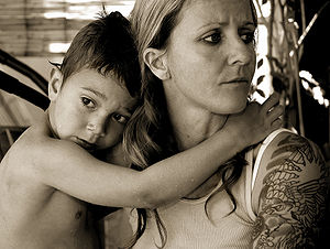 English: Mother with tatooed arm and wet child.