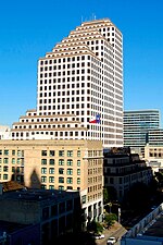 View from perhaps another building of One American Center. The building is white with red lining, and staircases at the top.