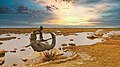 Statue of Lam-ang wrestling a crocodile at Kapurpurawan Rock Formation on sunset