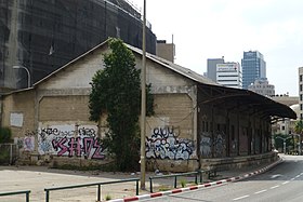 Blick 2014 aufs alte Zollamt mit Laderampe zu den Gleisen, jetzt Fahrbahn des Rechov ha-Rakkevet, und Abbruchwand voller Graffiti, wo bis 1971 das Bahnhofsgebäude in gleicher Dimension anschloss