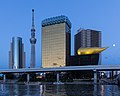 Image 12 Asahi Breweries Photograph credit: Basile Morin Asahi Breweries is a Japanese global beer, spirits, soft drinks and food business group. This photograph, taken during the blue hour with a full moon, shows the headquarters of Asahi Breweries in Sumida, Tokyo, as viewed from the wharf on the Sumida River near Azuma Bridge. The Asahi Beer Hall, topped by the Asahi Flame, designed by Philippe Starck, is visible on the right, with the Tokyo Skytree in the background on the left. More selected pictures