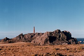 Vista de Cabo Blanco desde el sur. Se observa también el Faro Cabo Blanco (foto tomada en enero de 1999).