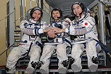 Lindgren (left) alongside crewmates Oleg Kononenko and Kimya Yui (right). Expedition 42 backup crew members in front of the Soyuz TMA spacecraft mock-up in Star City, Russia.jpg