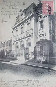 Façade principale vue latéralement depuis la rue, au tournant du XXe siècle.