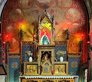 Le retable avec des panneaux peints surmonté par la Vierge noire