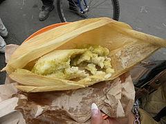 Tamal vert enveloppé dans une spathe de maïs.