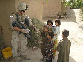 Operation Moshtarak; A U.S. Marine hands out candy to children while conducting counterinsurgency operations in Marjah, Afghanistan 2010 U.S. Marine Hearts and Minds.jpg