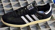 A single black Adidas samba on the floor