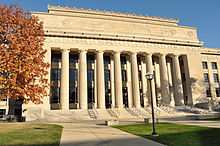 White-colored stone building with columns in the center of the facade c. 1924