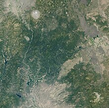 A satellite image from 2001 shows a distinct brown fire scar surrounded by green