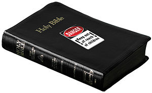 English: holy bible with warning sticker 'keep...