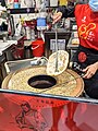 Cooking Jingzhou-style guokui in the traditional cylindrical oven