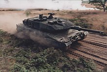The Leopard 2A5 can be recognized for its angular spaced armour on the turret cheeks and 44-calibre 120 mm main gun. Een Leopard 2A5 gevechtstank op snelheid 1999 2155 501335.jpg