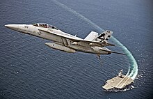 An F/A-18F Super Hornet from VX-23 flies over the USS Gerald R. Ford (CVN-78), the world's largest aircraft carrier, and the largest warship ever constructed F-A-18F Super Hornet flies over the USS Gerald R. Ford.jpg