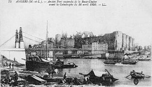 Carte postale ancienne montrant un pont suspendu, avec des navires en bois au premier plan, le château et la ville à l'arrière-plan.