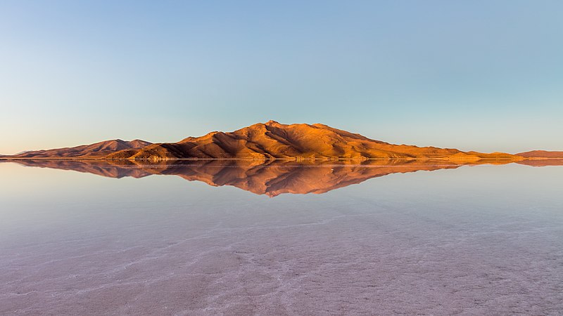 圖為包圍烏尤尼鹽沼的山脈的日出景觀，該鹽沼位於玻利維亞西南部波托西省的丹尼爾坎波斯省，佔地10,582平方公里，是世界第一大的鹽沼。雨季期間（12月至2月）有着壯麗非常的反射景觀。