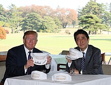 Shinzo Abe and US President Trump in 2017 with "MAGA"-style hats reading "Donald & Shinzo, Make Alliance Even Greater" Shinzo Abe and Donald Trump in Kawagoe (1).jpg