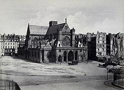 Vue de l'église Saint-Germain-l'Auxerrois en 1858 après l'agrandissement de la place du Louvre et avant la construction de la mairie du 1er arrondissement (photo d'Édouard Baldus) : longeant l'église, l'ancien cloître Saint-Germain-l'Auxerrois était situé dans l'espace libre autour de l'église.