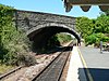 The northern end of the platform at Axminster station in 2006 showing the now disused extension and narrow walkway under the road bridge