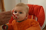 Ein Baby wird mit Grießbrei gefüttert