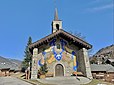 La Chapelle de Mussillon Notre-Dame-des-Neiges à Méribel, au cœur du domaine des Trois-Vallées en Savoie. Afin de suspendre des pots de fleurs de chaque côté de la façade, sont fixés des potences métalliques réalisées par la société Ferodem.