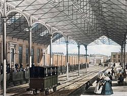 Euston station in London, 1837. Note the open passenger carriages. Euston Station showing wrought iron roof of 1837.jpg