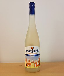 A bottle of Amarguinha Original on a wooden table, against a white background.