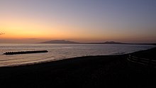 秋田湾、出戸浜海岸の夕日。彼方に男鹿半島を望む。