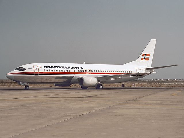 Boeing 737-400 with a white body, metallic belly and a red cheatline