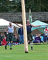 Photo d’un homme lançant un tronc d’arbre devant lui pour l’épreuve du Caber.