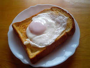 A piece of toast covered with a fried egg.