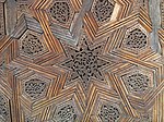 Carved geometric and arabesque details in the cedar wood doors of the lateral chambers off the courtyard