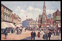 A postcard showing a streetscene of George Street looking South East towards Market Hill in the early 20th Century.