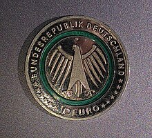 Offizielle Gedenkmünze, Seite mit dem Bundesadler. Text: Bundesrepublik Deutschland * 10 Euro Der grünliche, durchscheinende Polymerring ist zu erkennen.