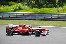 Massa lors de son Grand Prix national, au volant de sa Ferrari rouge, sous un grand soleil.