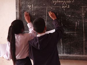 Pupils writing on the blackboard in a village ...