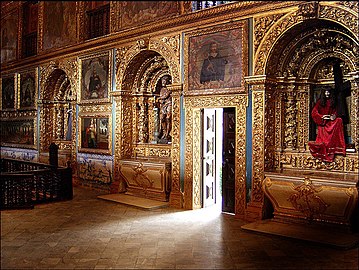 Mur latéral d'une chapelle dans lequel sont ouvertes plusieurs niches, chacune ornée de colonnes torsadées.