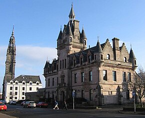 The sheriff court in Greenock (1869) is a typical Scottish Baronial building with crow-stepped gables and corbelled corner turrets. Greenock Sheriff Court.jpg