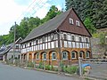 Wohnhaus (Umgebinde) und Stützmauern dahinter in Naturstein