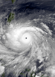 Photo satellite montrant une spirale de nuages blancs sur l'océan bleu et des terres vertes