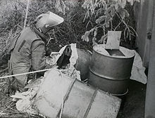 Oil-drum roadside IED removed from culvert in 1984 Home-made explosives packed in oil drums being dealt with by EOD Operator. MOD 45159058.jpg