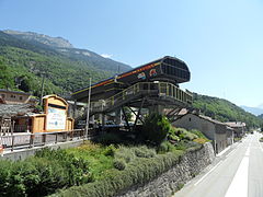 Photographie de la gare de départ de la télécabine 3 Vallées Express dans son ancienne version originelle au-dessus de la route, le toit a des lettres qui sont celles de l'appellation de la télécabine.